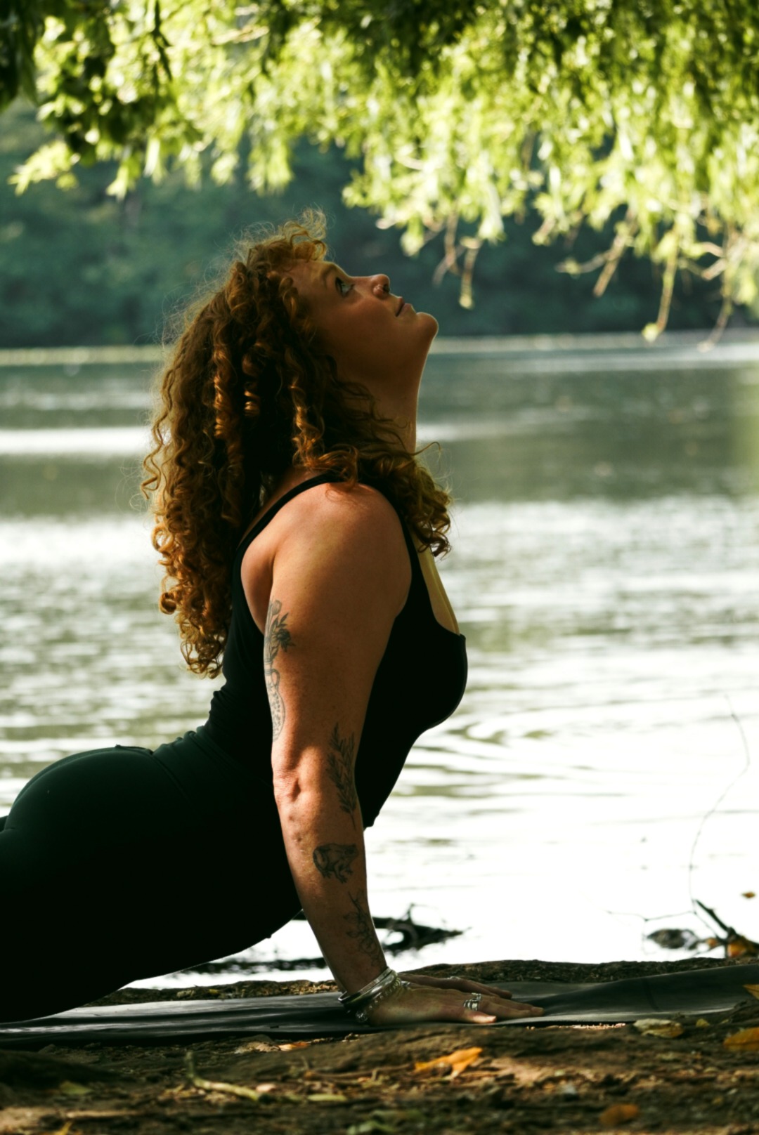 Grace in cobra pose, looking up toward the trees