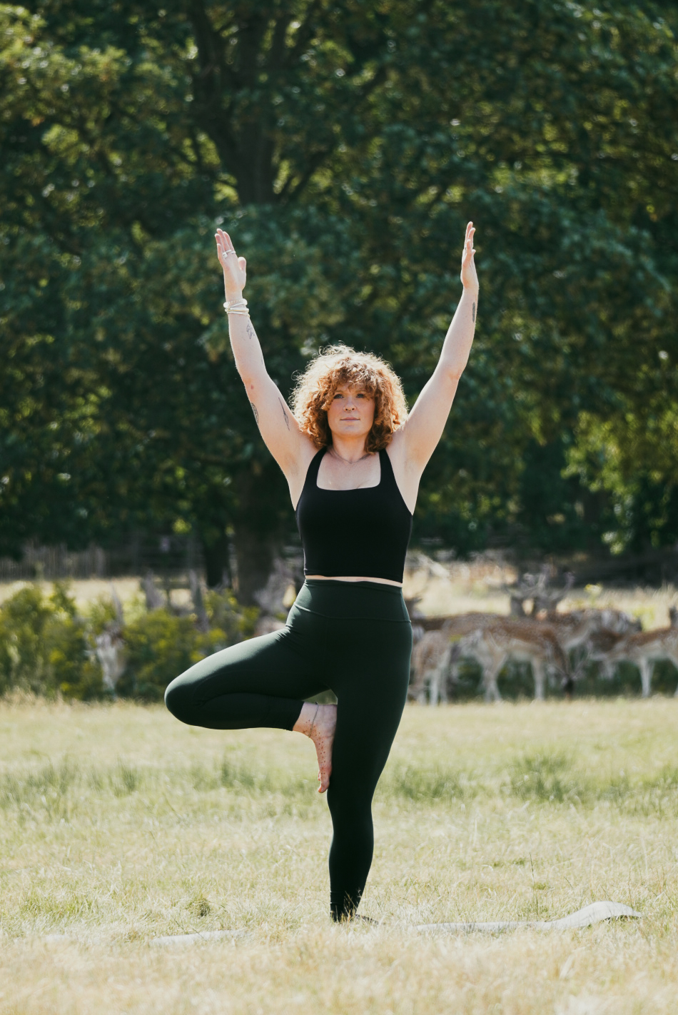 Grace in tree pose in a sunlit meadow